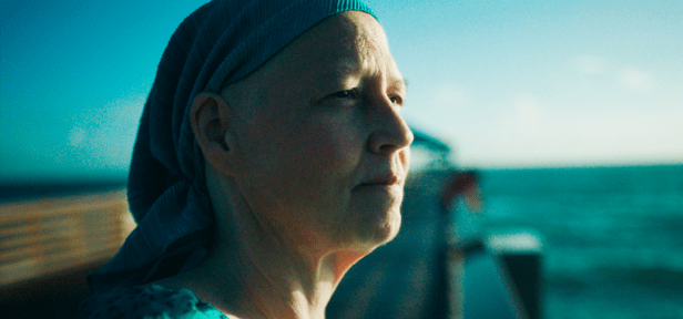 Image of a woman standing on a pier looking at the ocean