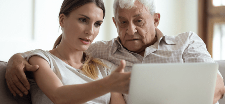 Image of a man sitting on a sofa looking at something on a tablet