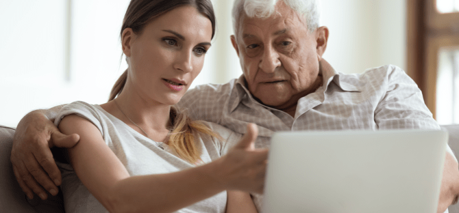 Image of a man sitting on a sofa looking at something on a tablet