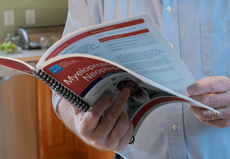 Close up image of man's hands holding a manual open