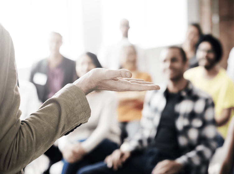 Image of a group of people listening to a speaker