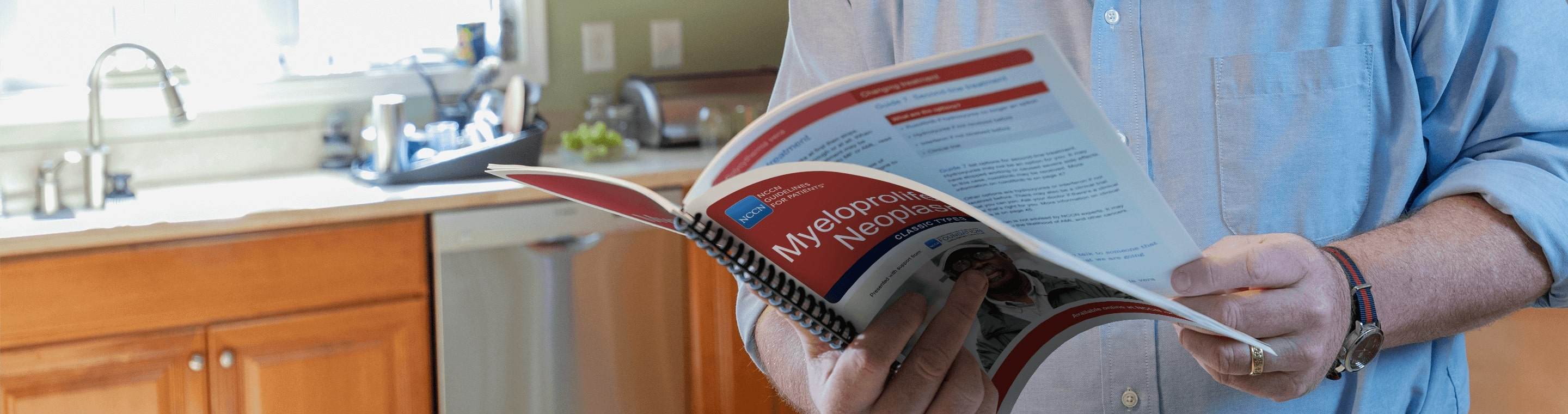 Close up image of man's hands holding a manual open