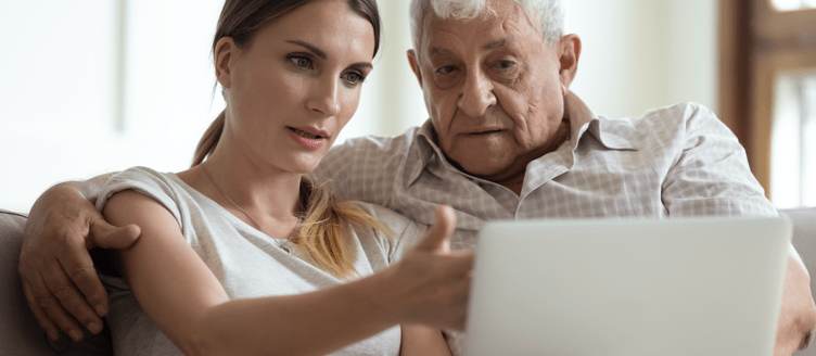 Image of a man sitting on a sofa looking at something on a tablet