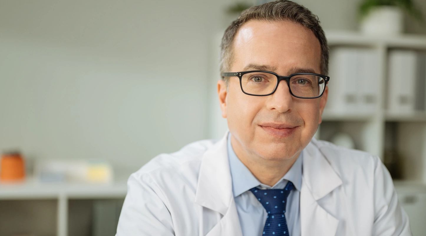 Male doctor with glasses looking forward